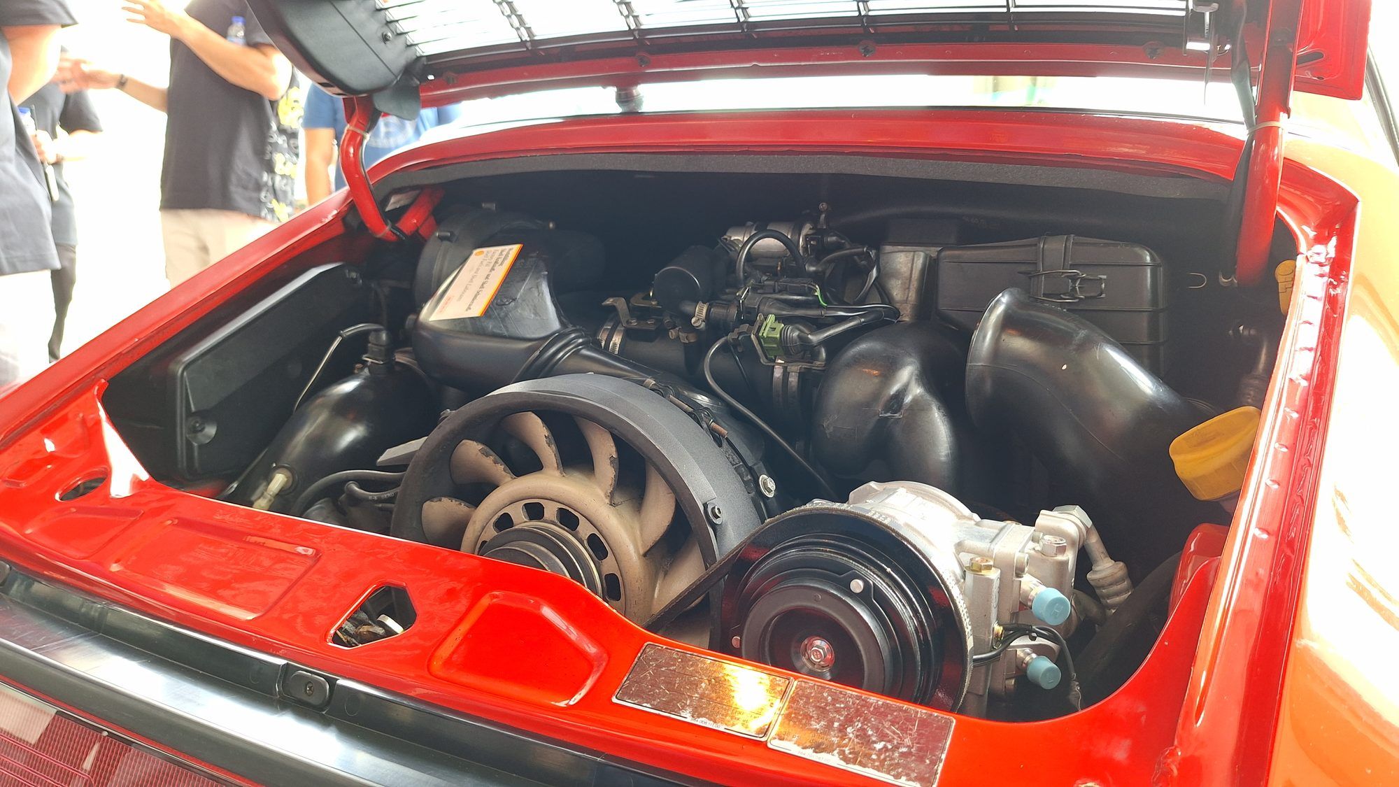 Air-cooled engine in a red classic Porsche 911, with the engine lid open